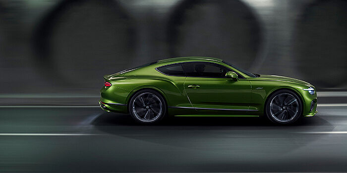 Bentley Casablanca Bentley Continental GT coupe in Tourmaline Green paint driving in profile on a dark road