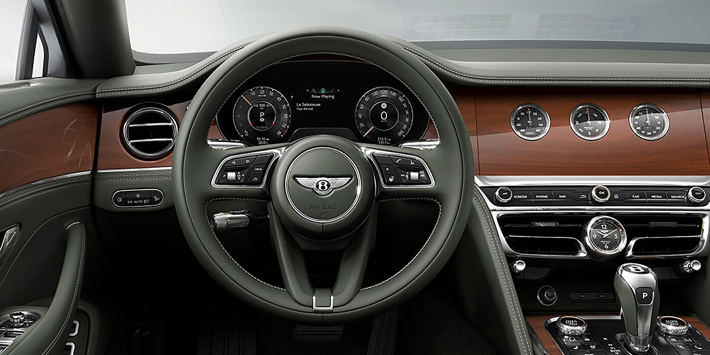 Bentley Casablanca New Bentley Flying Spur sedan front cabin in Cumbrian Green hide and Crown Cut walnut veneer showing steering wheel and Rotating Display with three clocks on face