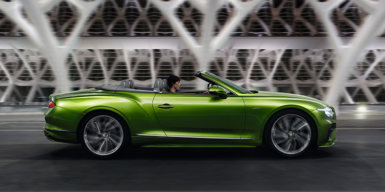 Bentley Casablanca Bentley Continental GTC Speed convertible side profile in Tourmaline Green paint driving dynamically on a bridge at night