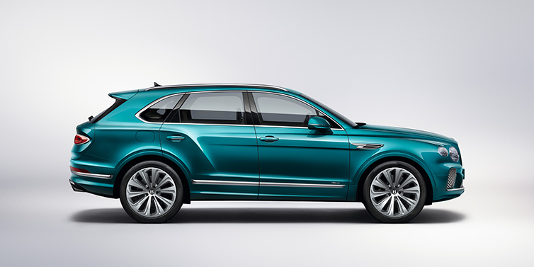 Bentley Casablanca Bentley Bentayga Azure SUV in profile in Topaz blue paint featuring 22 inch 10 spoke directional wheels against a white background