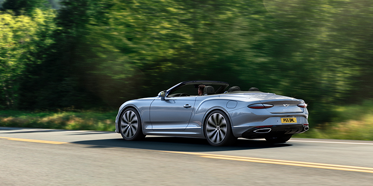 Bentley Casablanca New Bentley Continental GTC convertible side view in Silverlake paint with 22 inch ten spoke wheels driving dynamically on a country road
