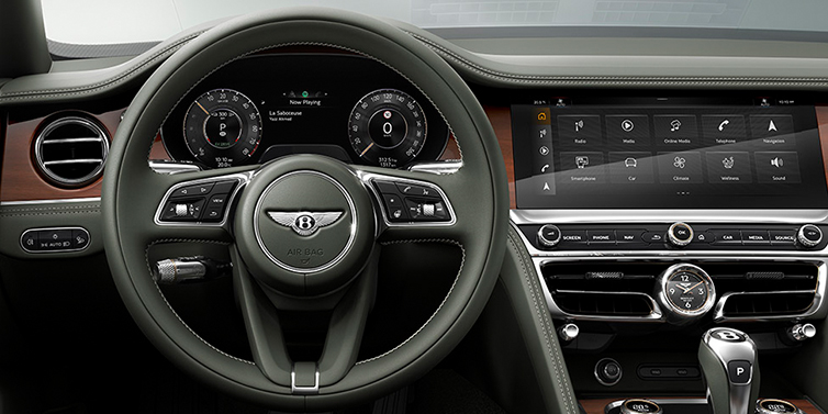 Bentley Casablanca New Bentley Flying Spur front cabin interior in Cumbrian green hide with Crown Cut walnut veneer showing steering wheel and driver controls
